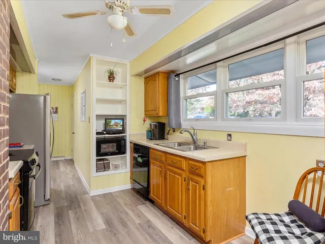 a kitchen that has a sink a stove and wooden floor