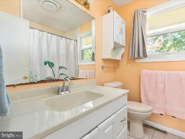 a bedroom with a large bed and a flat tv screen on dresser