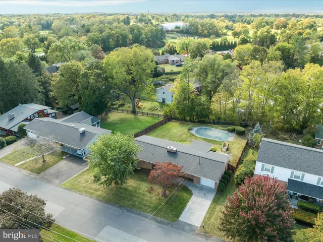 an aerial view of residential houses with outdoor space and trees