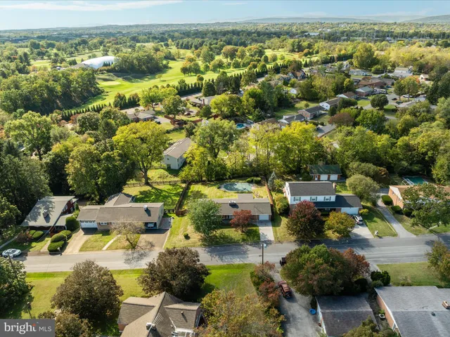 a view of residential houses with outdoor space and trees
