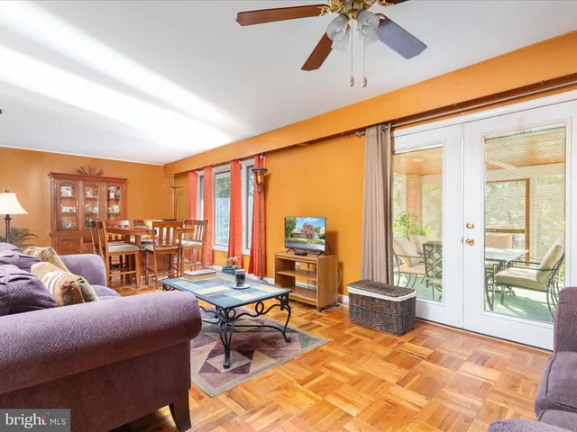 a kitchen with stainless steel appliances granite countertop a refrigerator a sink dishwasher a stove and a dining table with wooden floor