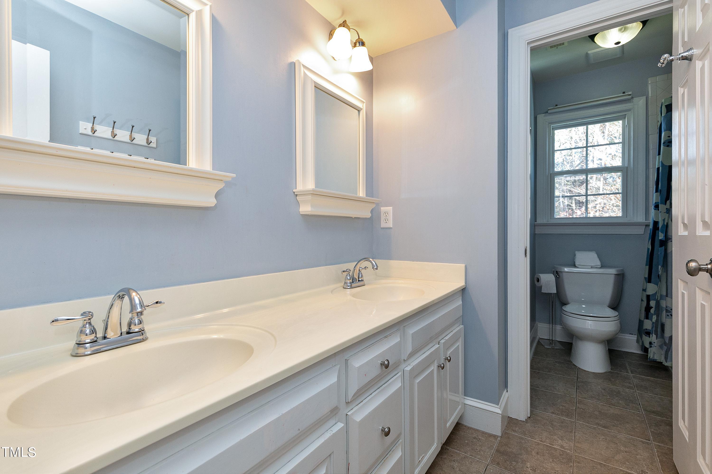 8928 Windjammer Drive Raleigh, NC 27615 - Photo 28 of 44 Upstairs bath has double vanity, tub and toilet in separate area and functional linen closet behind the door