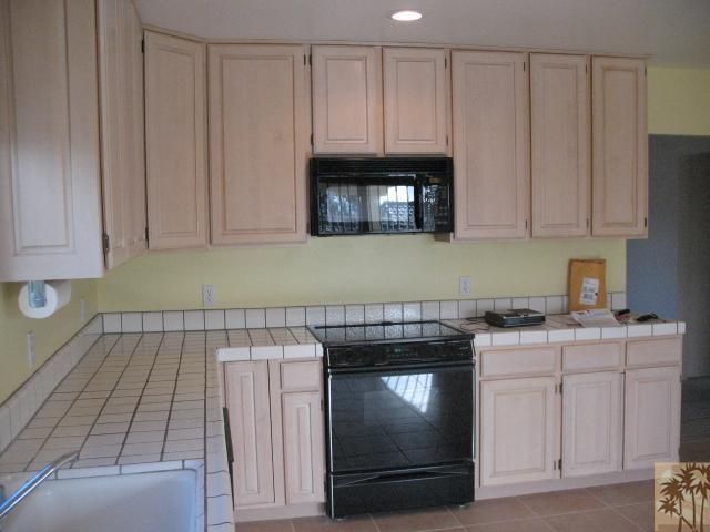67145 San Ardo Road Desert Hot Springs, CA 92240 - Photo 4 of 20 a kitchen with granite countertop white cabinets and stainless steel appliances