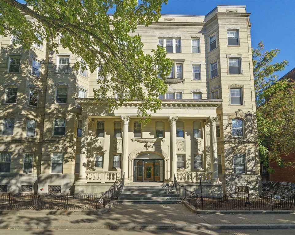 a front view of a building with a tree