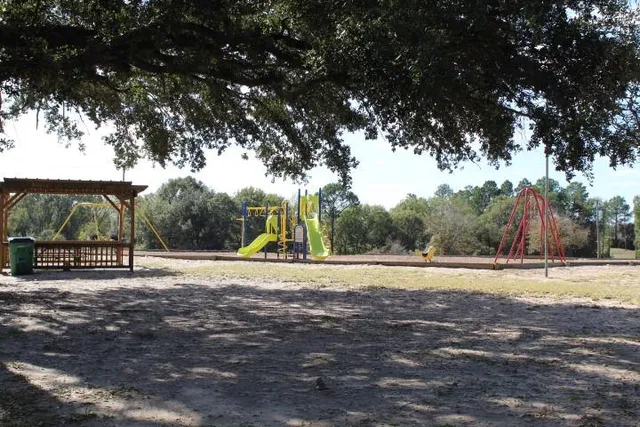 a view of a lake with a yard and large trees
