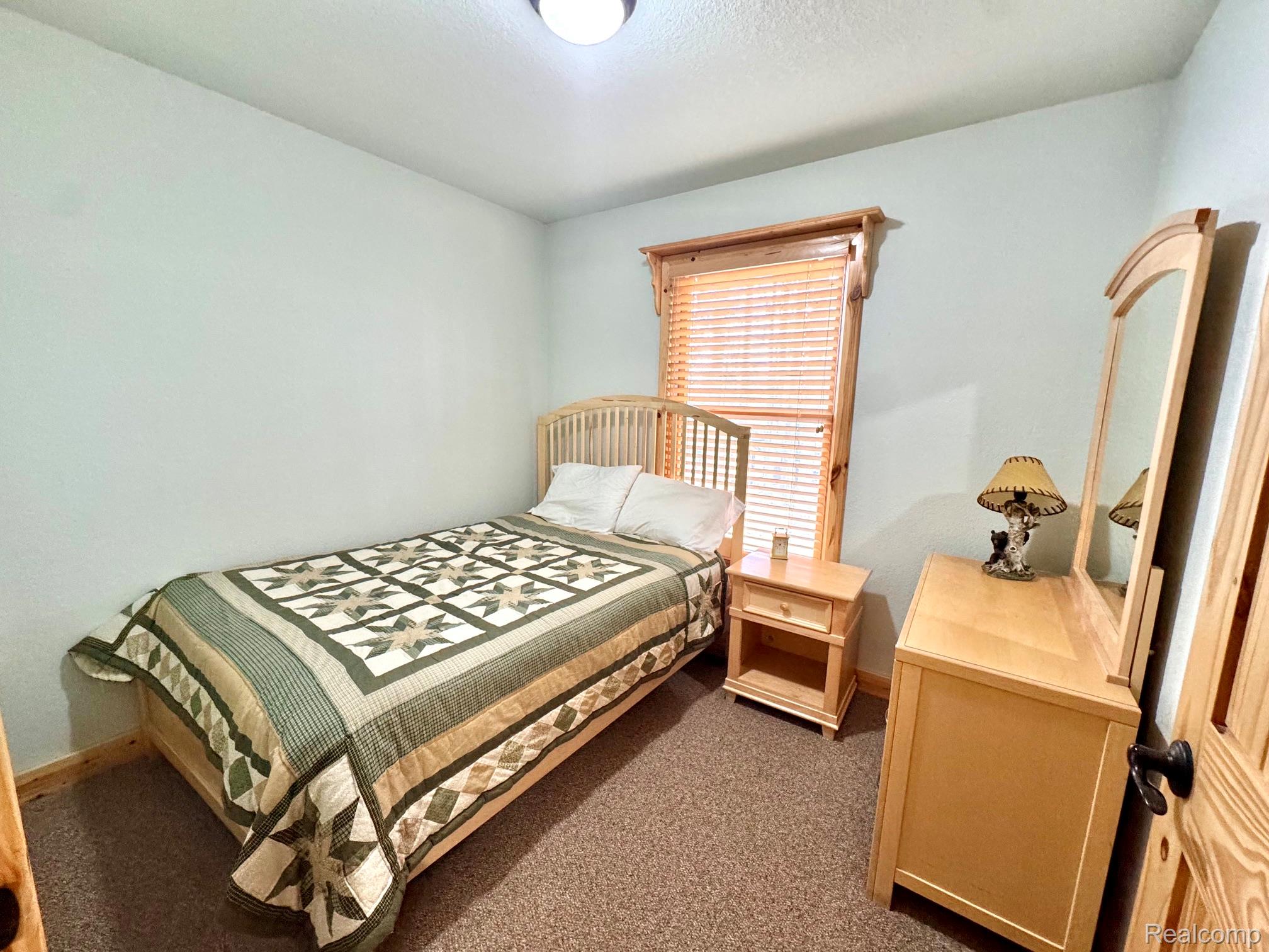 10931 North Roberts Road Frederic, MI 49733 - Photo 18 of 33 Bedroom featuring dark carpet and baseboards