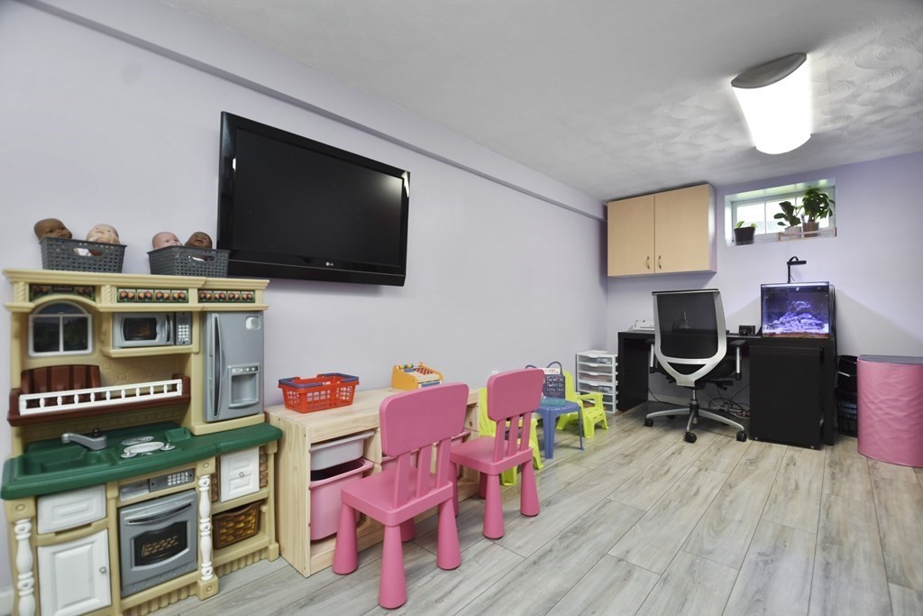 8 Deb Road Woburn, MA 01801 - Photo 26 of 34 a living room with furniture a flat screen tv and kitchen view