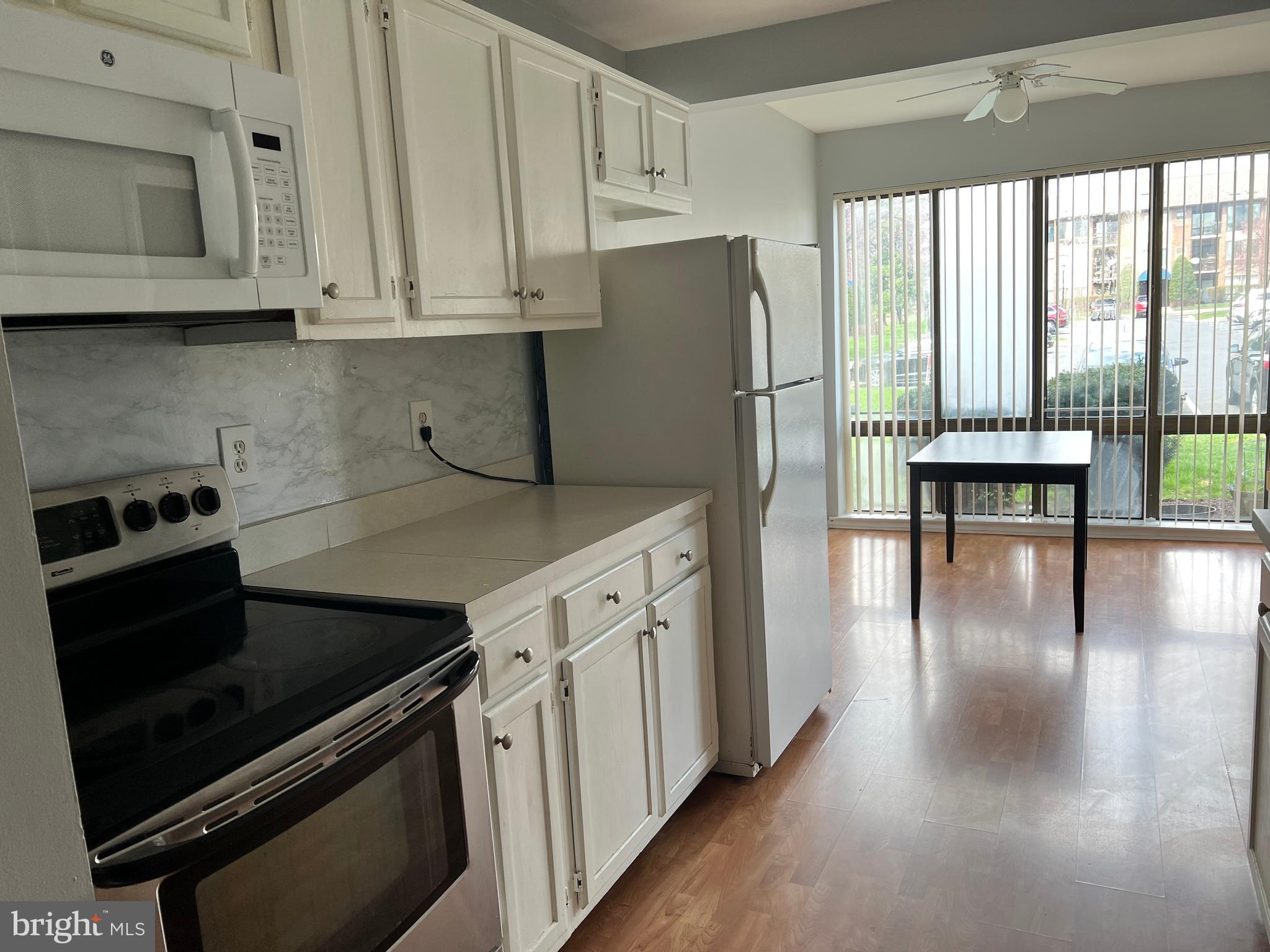 8141 Needwood Road, Unit 104 Derwood, MD 20855 - Photo 11 of 42 a kitchen with stainless steel appliances granite countertop a stove a refrigerator and a microwave