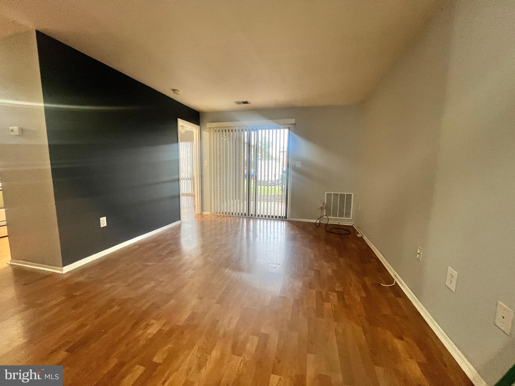 8141 Needwood Road, Unit 104 Derwood, MD 20855 - Photo 15 of 42 a view of an empty room with wooden floor and a window
