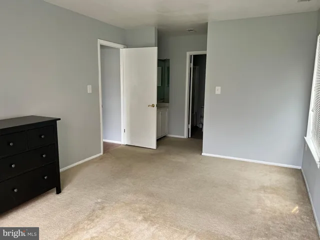 an empty room with closet and mirror