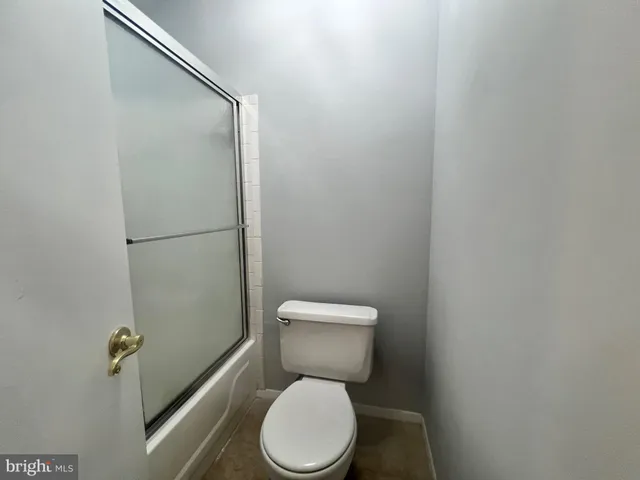 a white toilet sitting next to a shower