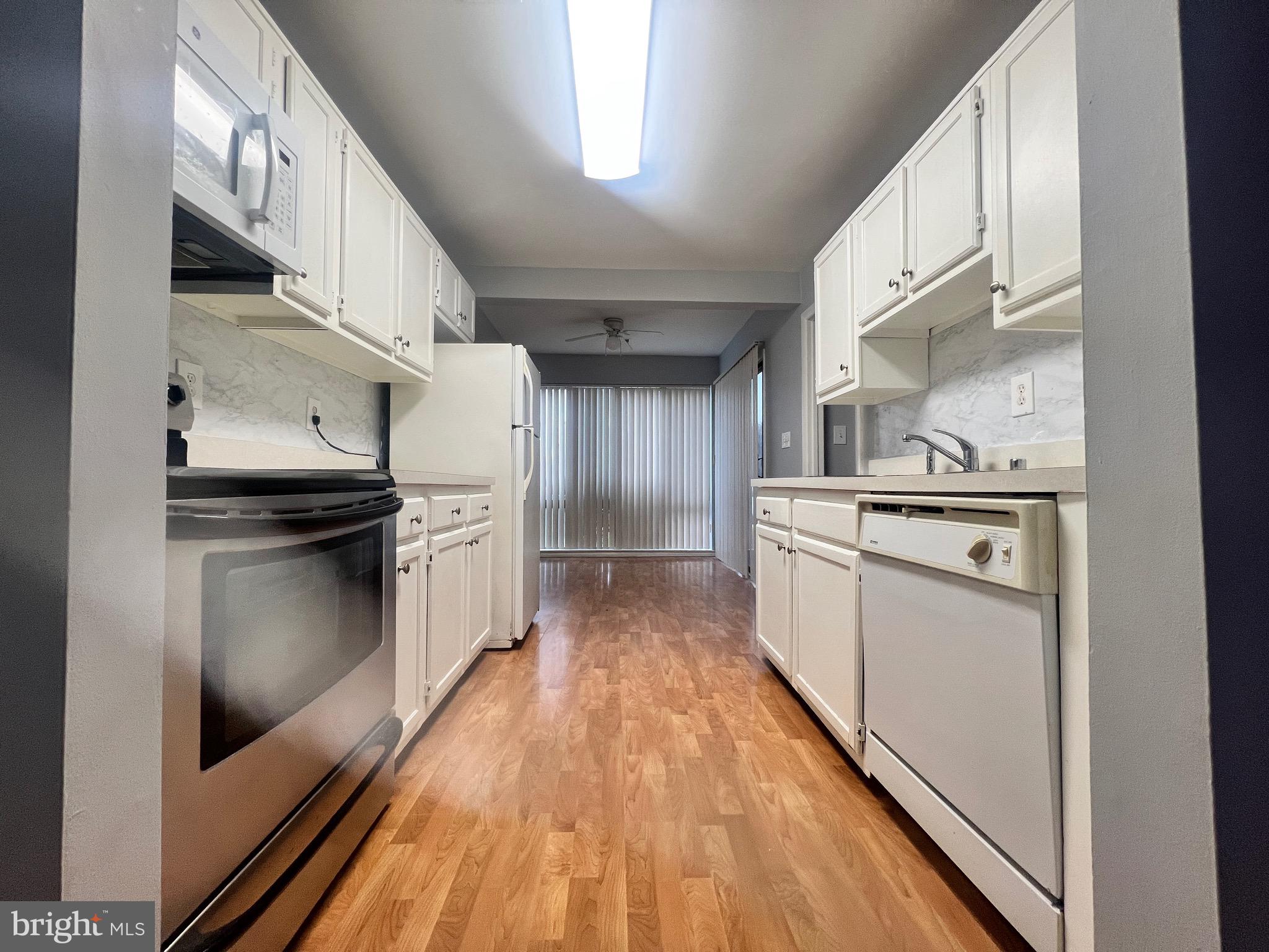 8141 Needwood Road, Unit 104 Derwood, MD 20855 - Photo 7 of 42 a kitchen with stainless steel appliances granite countertop a refrigerator a stove and a sink