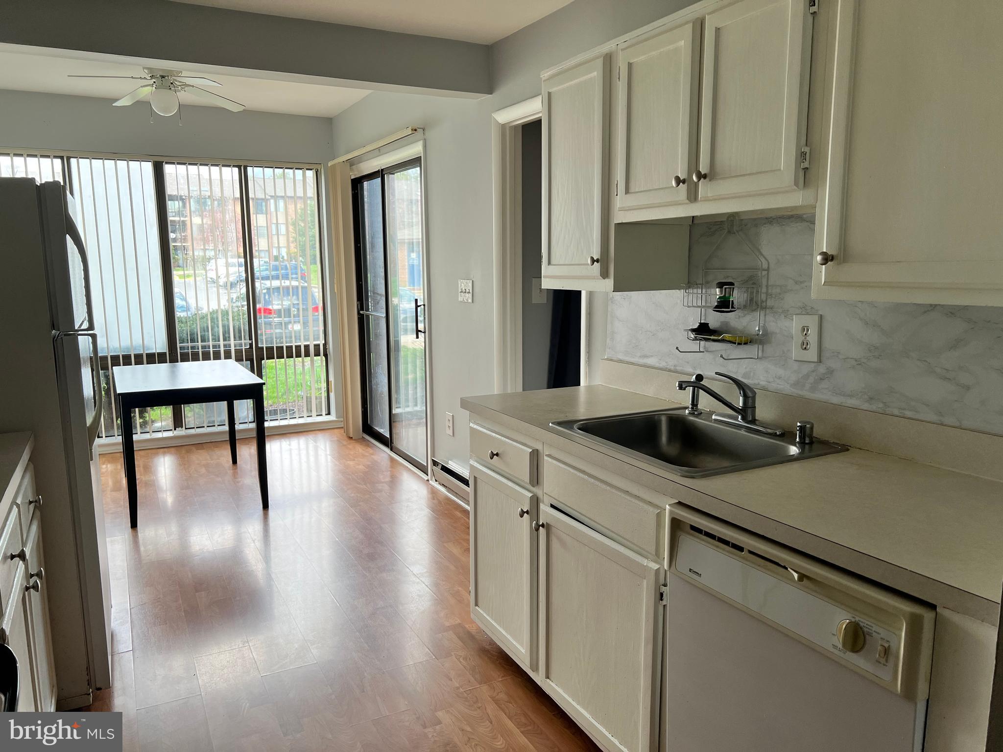 8141 Needwood Road, Unit 104 Derwood, MD 20855 - Photo 10 of 42 a kitchen with a sink a stove and white cabinets