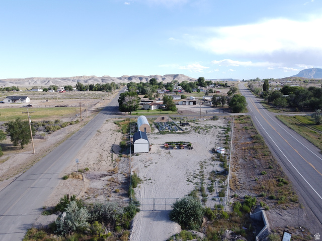 345 North Main Street Clawson, UT 84516 - Photo 1 of 17 Expansive land parcel featuring a gated entrance, a white utility building, and a hoop house structure