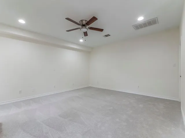 an empty room with a ceiling fan and window