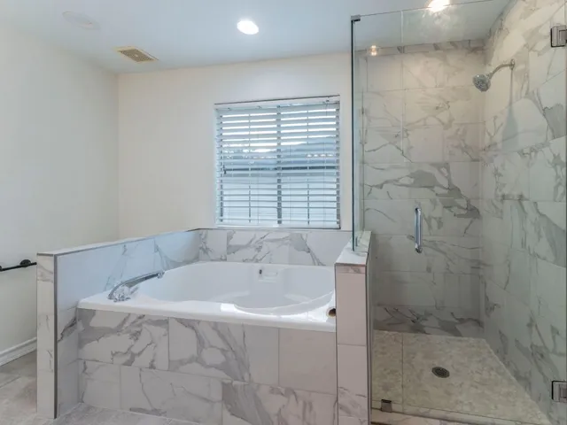 a bathroom with a bathtub and shower