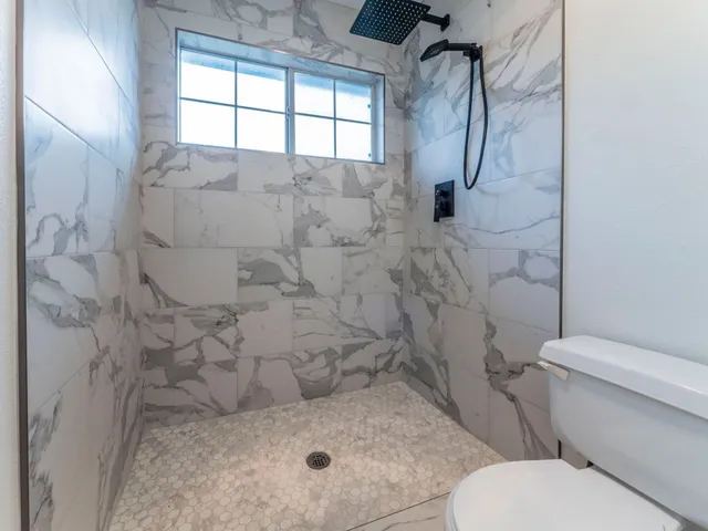a bathroom with a toilet and a shower