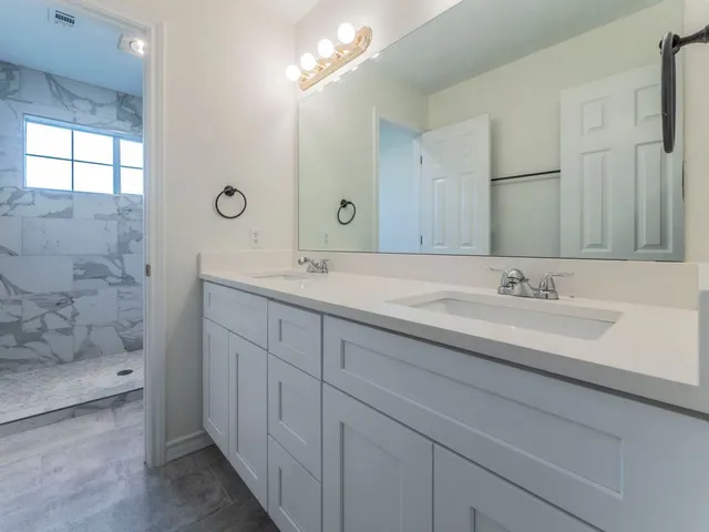 a bathroom with a sink double vanity and a mirror