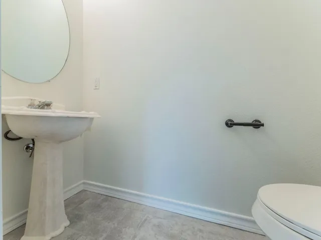 a bathroom with a sink mirror and toilet