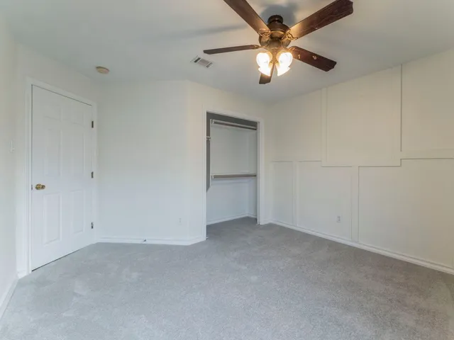 a view of an empty room with a ceiling fan