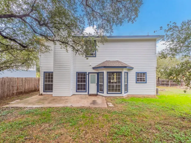 a view of a house with a yard and fence