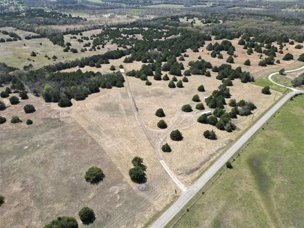 an aerial view of white house with a yard