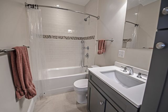 a bathroom with a sink a toilet a mirror and shower