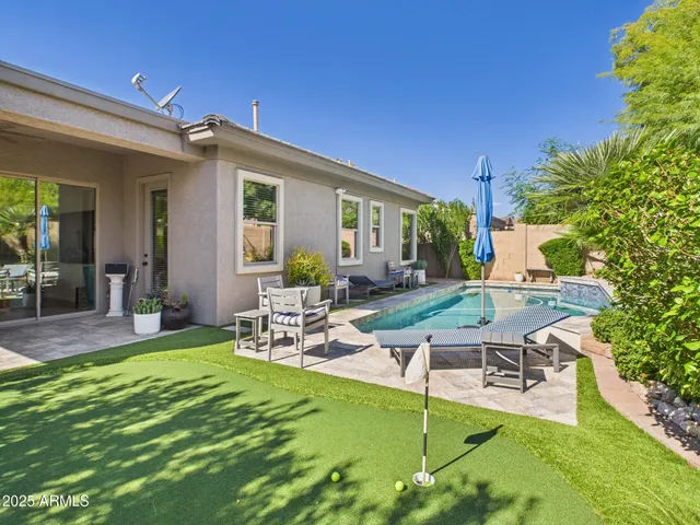 a view of a chair and table in backyard of the house