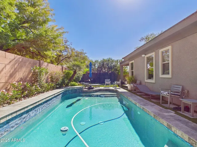a swimming pool with outdoor seating and yard