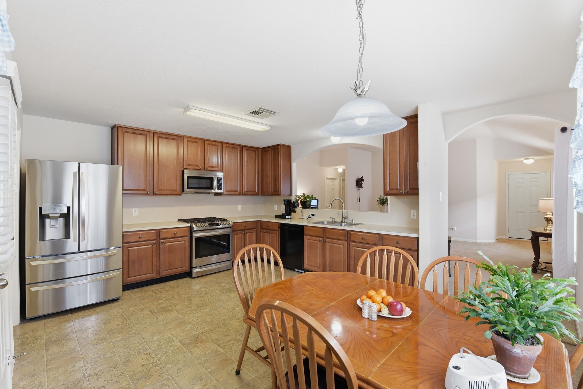 21639 Falvel Misty Drive Spring, TX 77388 - Photo 6 of 11 a kitchen with granite countertop stainless steel appliances a sink a stove a dining table and chairs