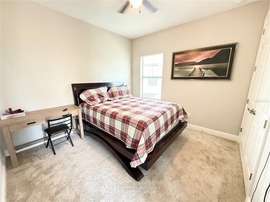 14820 Paddock Pond Avenue Lithia, FL 33547 - Photo 14 of 21 a bedroom with a bed chair and a chandelier