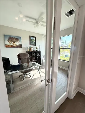 a workspace with wooden floor and windows