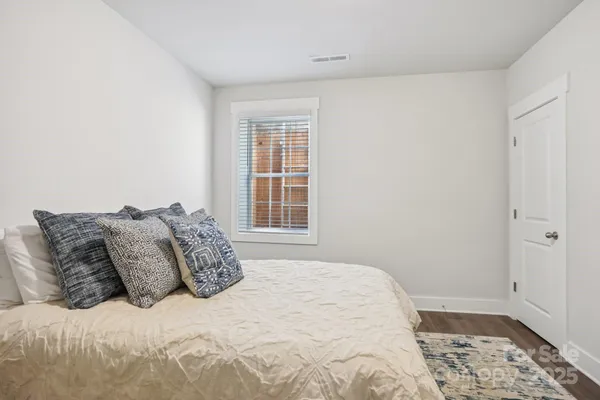 a large bed sitting in a bedroom next to a window