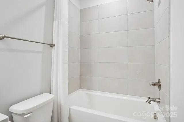 a white bath tub sitting next to a toilet
