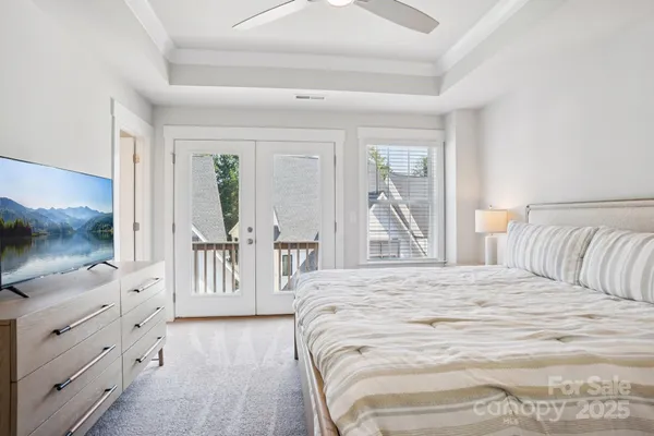 a bedroom with a large bed and a flat tv screen on dresser