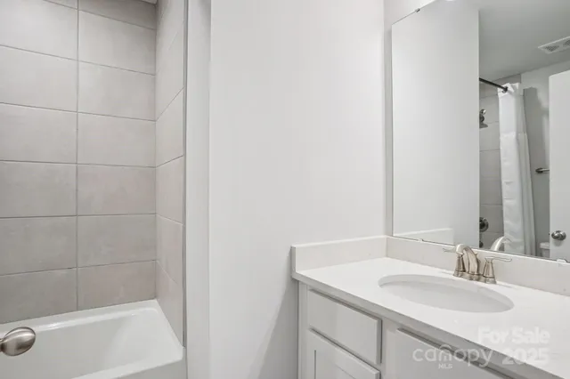 a bathroom with a granite countertop sink a mirror and a bathtub