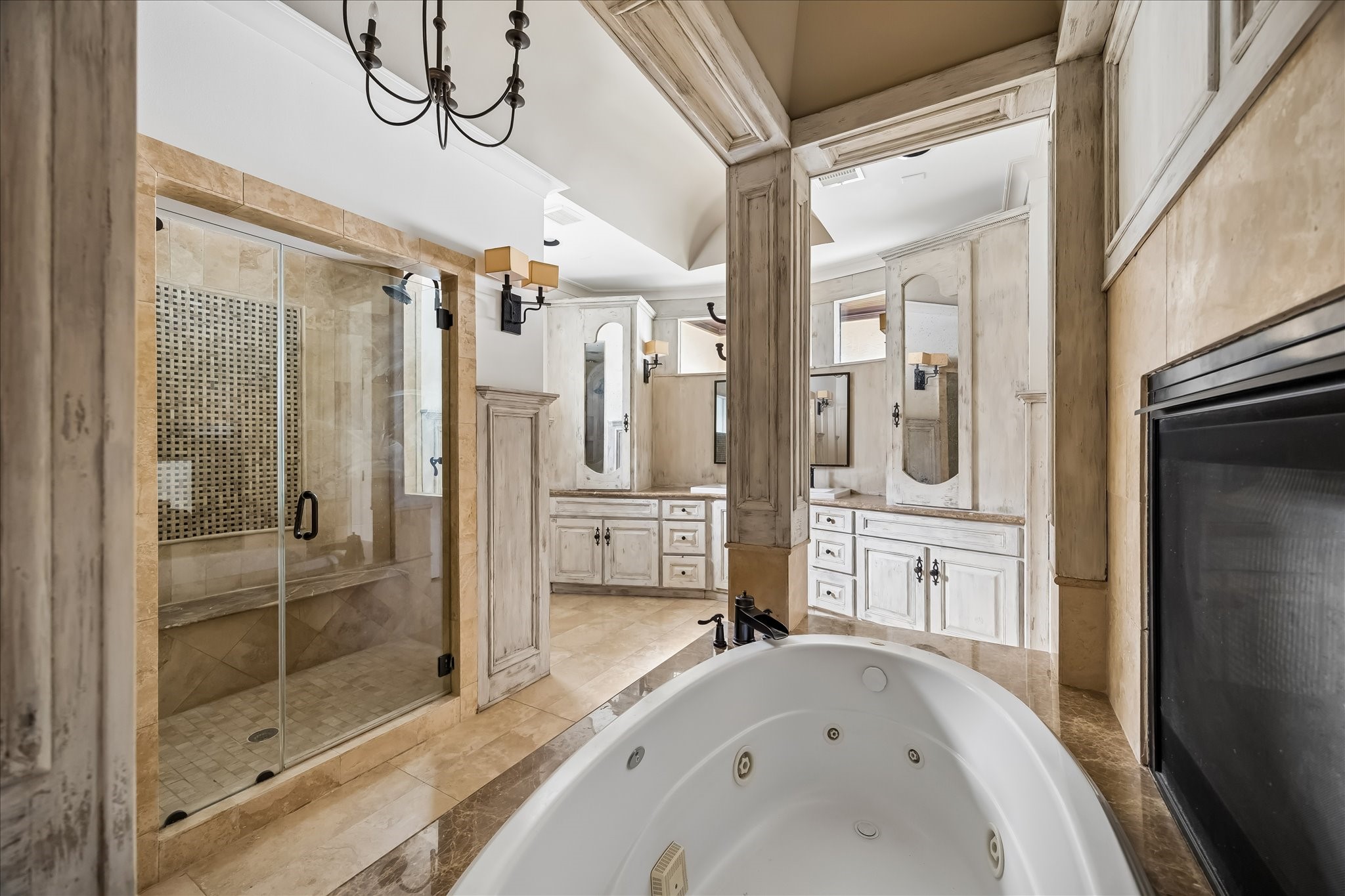 2246 Branard Street Houston, TX 77098 - Photo 28 of 40 A spa-like primary bath showcasing the jetted soaking tub, oversized walk-in shower, dual vanities, and beautifully detailed custom cabinetry accented by warm stone finishes.