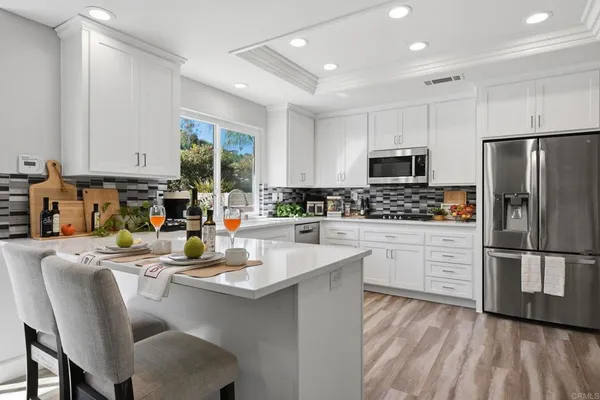 a kitchen with stainless steel appliances granite countertop a refrigerator and microwave