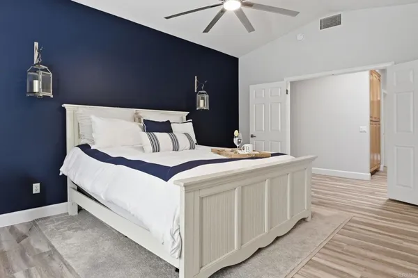 a spacious bedroom with a bed and glass couch