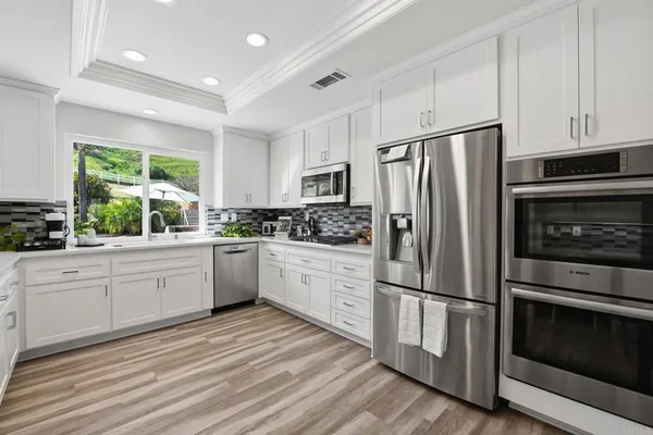 a kitchen with a sink window and cabinets
