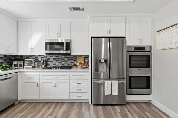 a kitchen with granite countertop white cabinets and white appliances