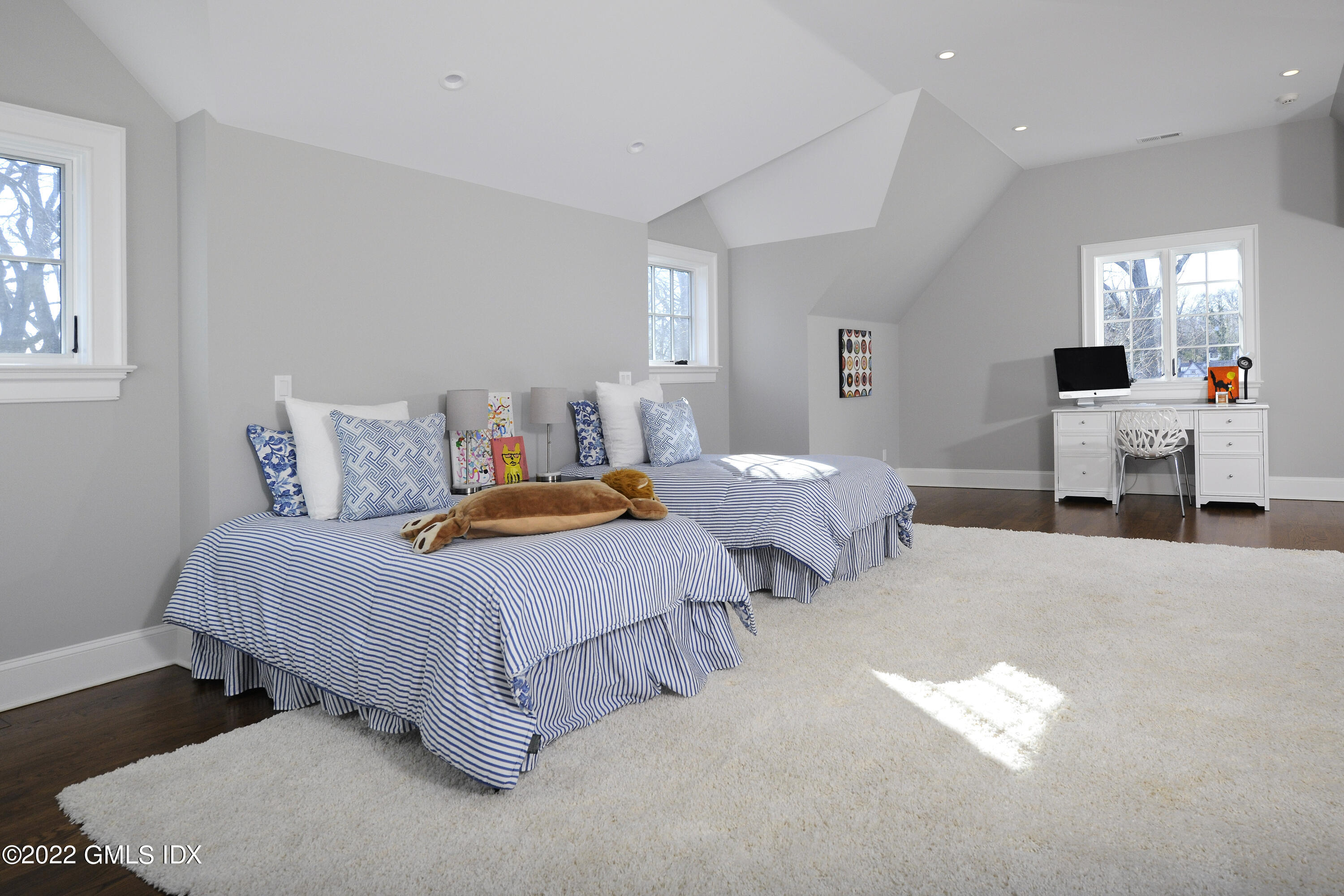 113 Woodside Drive Greenwich, CT 06830 - Photo 23 of 37 a spacious bedroom with two beds and painting on the wall