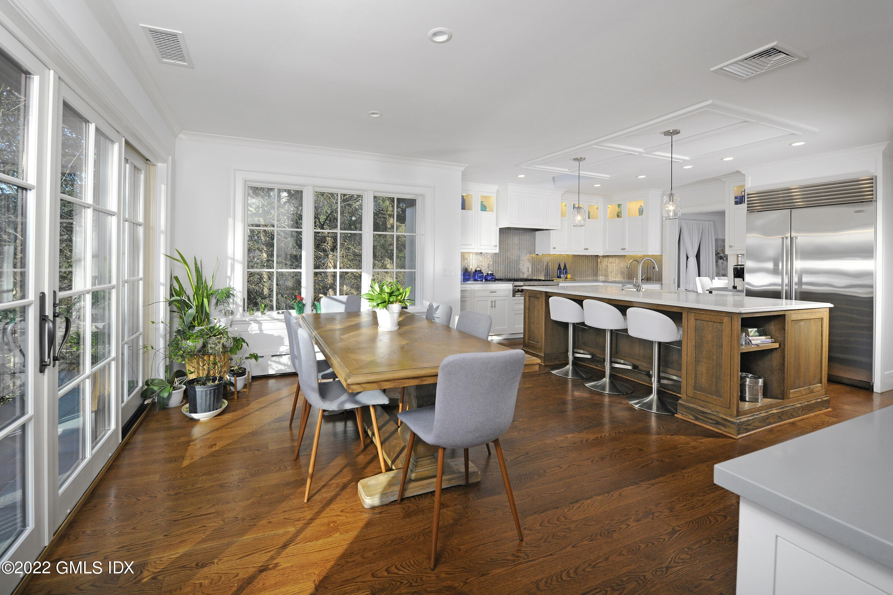 113 Woodside Drive Greenwich, CT 06830 - Photo 6 of 37 a dining room with stainless steel appliances kitchen island granite countertop a table chairs and a living room view