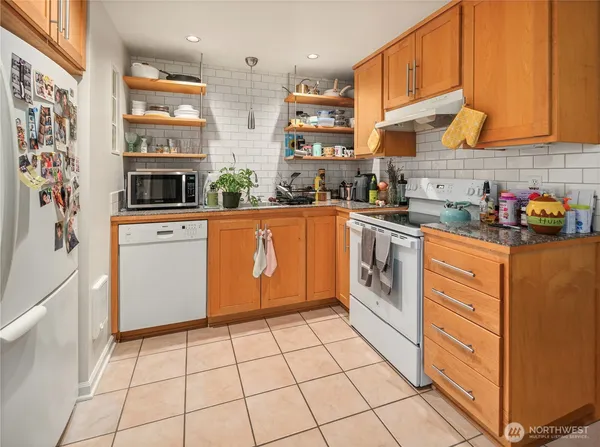 a kitchen with stainless steel appliances a stove a sink and white cabinets