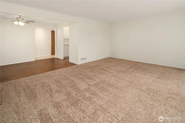 a view of an empty room and a chandelier fan