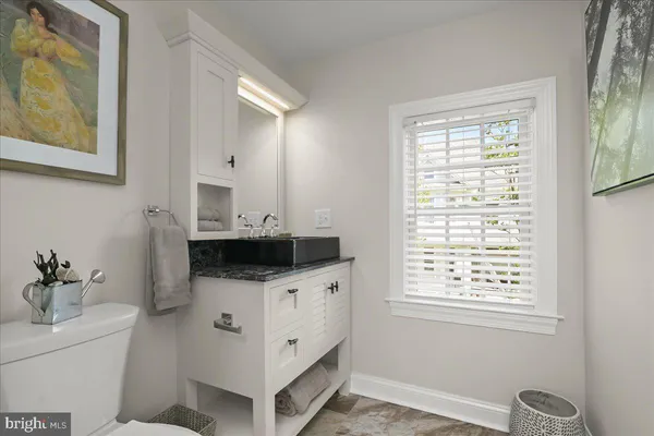 a bathroom with a granite countertop sink and a mirror
