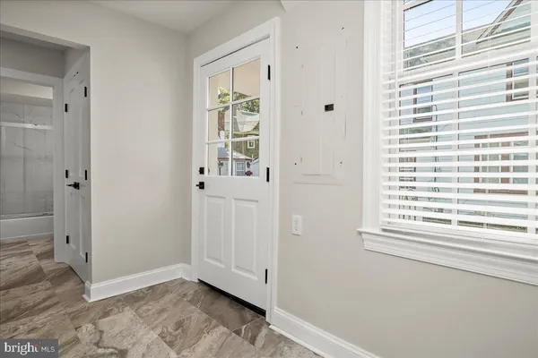 a room with a chandelier furniture a window and wooden floor