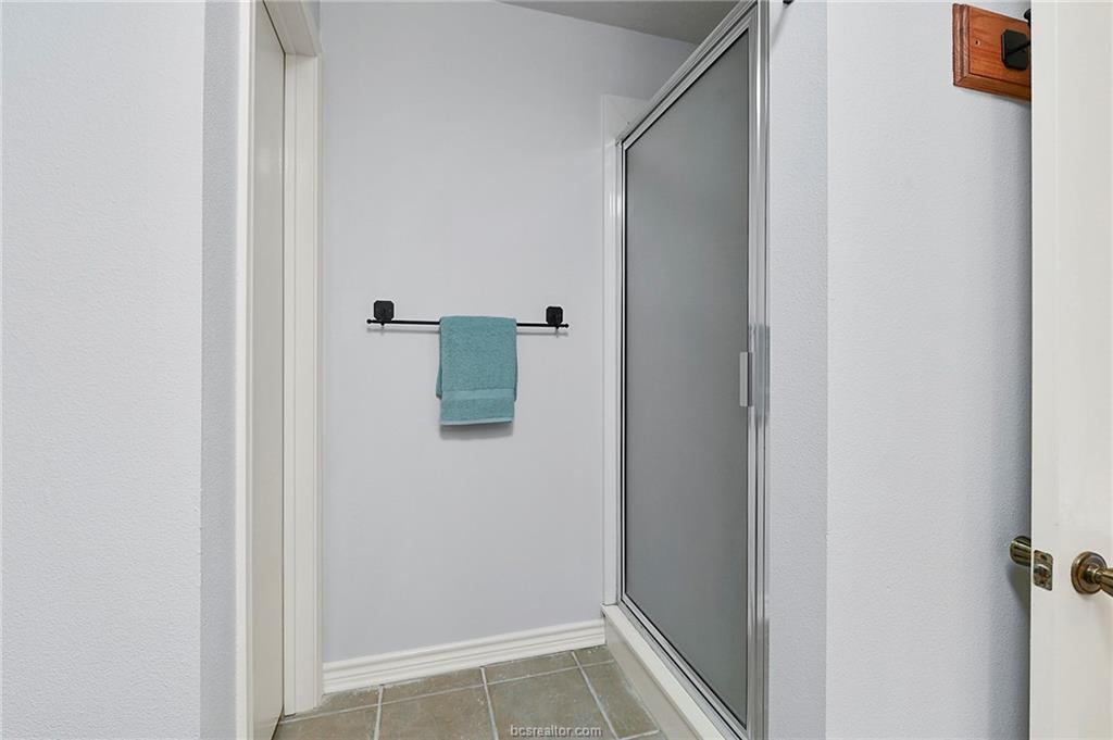 1031 Rose Circle College Station, TX 77840 - Photo 17 of 26 Bathroom featuring light tile patterned floors and a shower stall