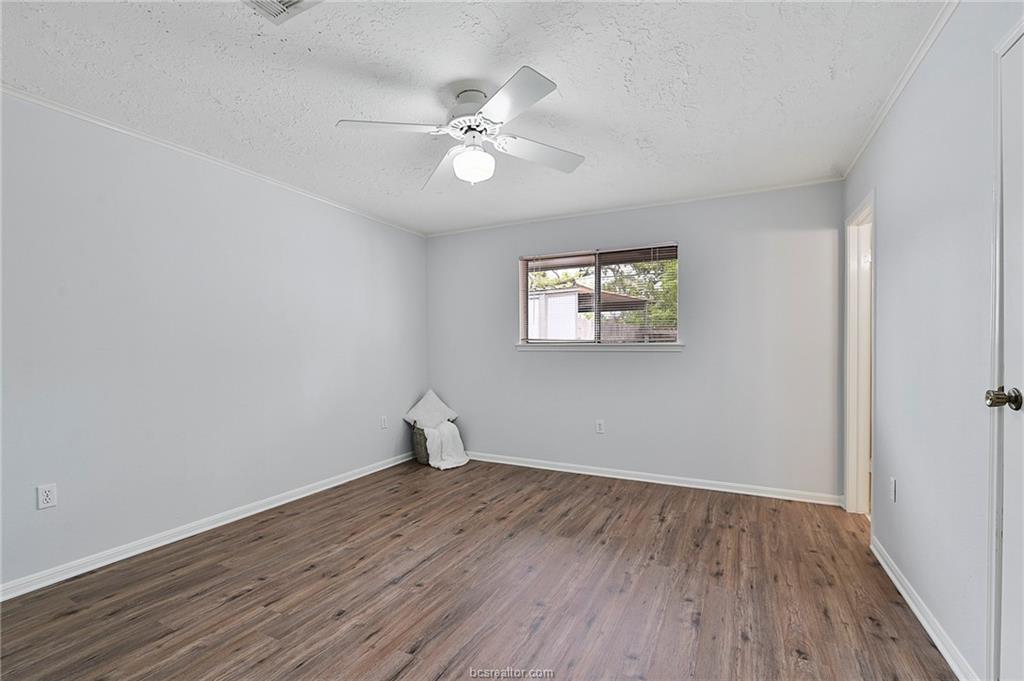 1031 Rose Circle College Station, TX 77840 - Photo 18 of 26 Spare room with wood finished floors, ornamental molding, a textured ceiling, and a ceiling fan