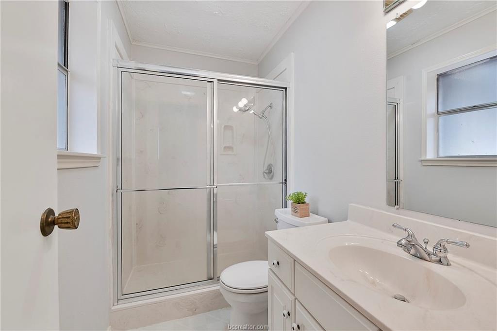 1031 Rose Circle College Station, TX 77840 - Photo 19 of 26 Full bathroom featuring vanity, a stall shower, crown molding, and light tile patterned floors